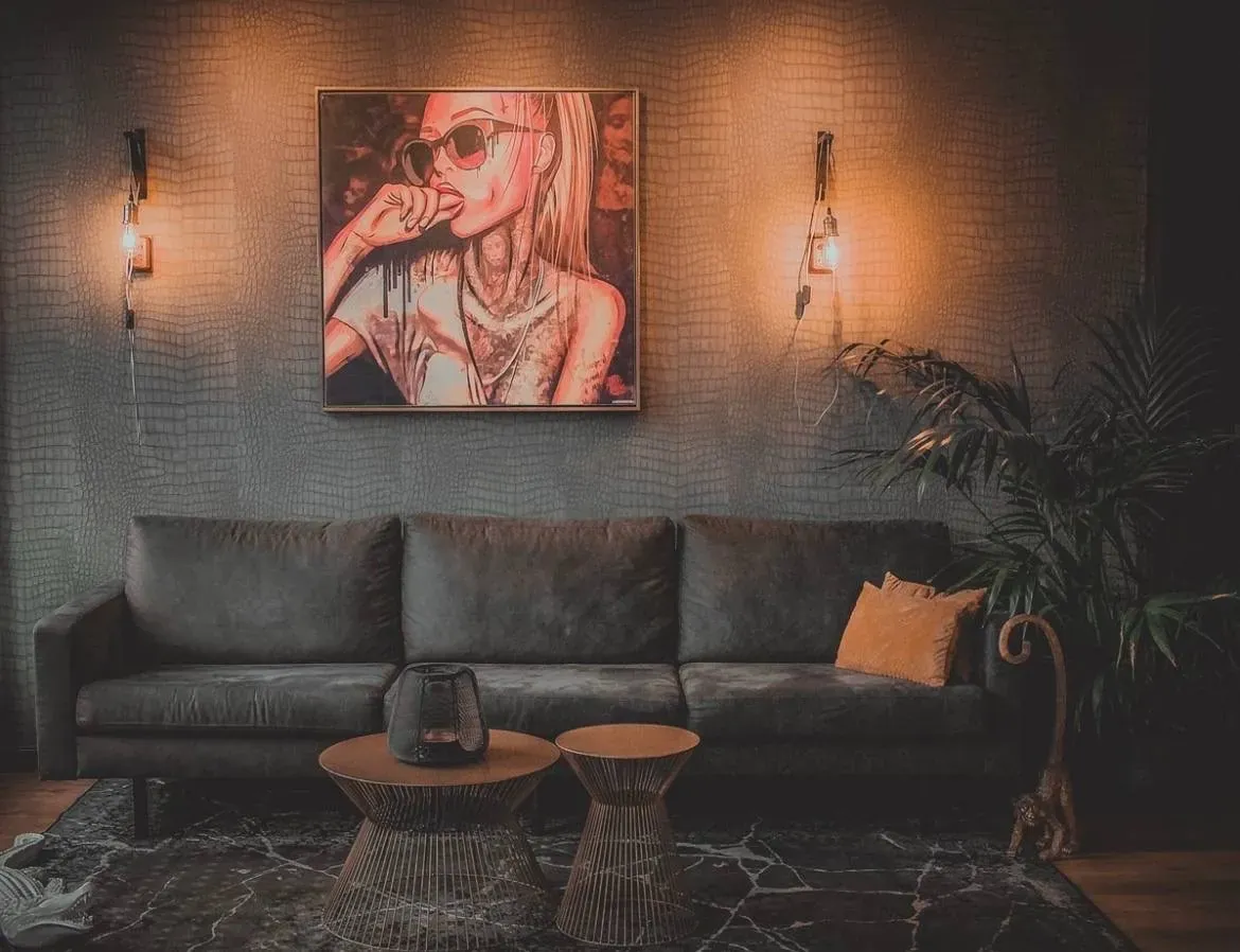 Lounge van de studio met warm wandlicht en leren bank